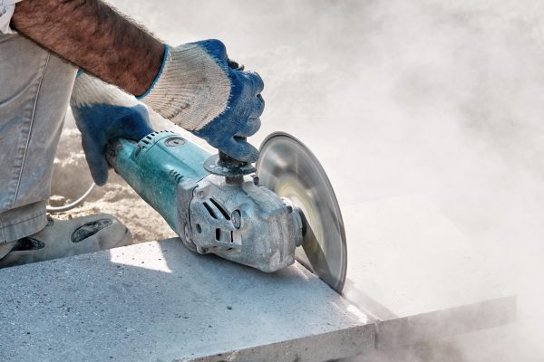 Hands,Of,A,Pavement,Construction,Worker,Using,An,Angle,Grinder